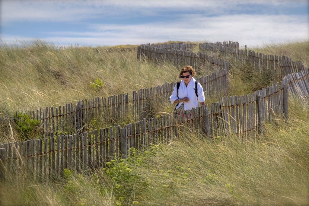 Turista in viaggio con Girolibero cammina tra le dune sulla costa della Bretagna